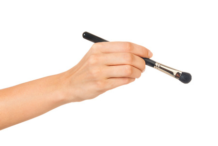 Professional make-up brush cosmetic in female hand beautician isolated on white backgroundの写真素材