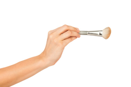 Professional make-up brush cosmetic in female hand beautician isolated on white backgroundの写真素材