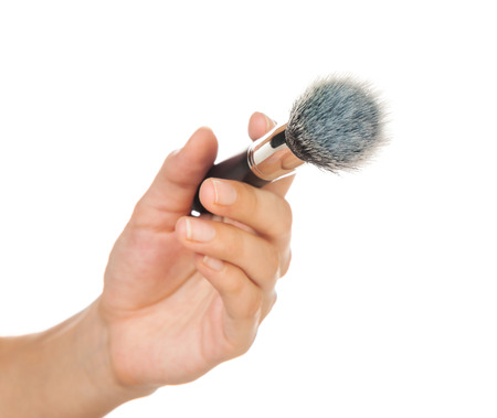 Professional make-up brush cosmetic in female hand beautician isolated on white backgroundの写真素材