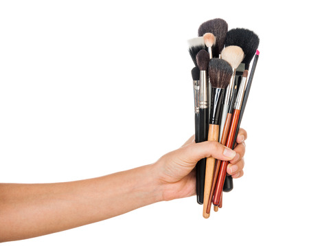 Professional make-up brush cosmetic in female hand beautician isolated on white backgroundの写真素材