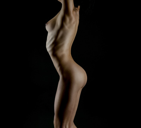 Sexy body nude woman. Naked sensual buttocks isolated on blackの写真素材