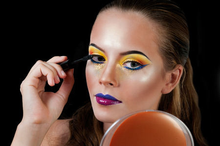 Professional Make up concept. Portrait of young beautiful woman with beauty makeup and perfect skin. Isolated on black backgroundの写真素材