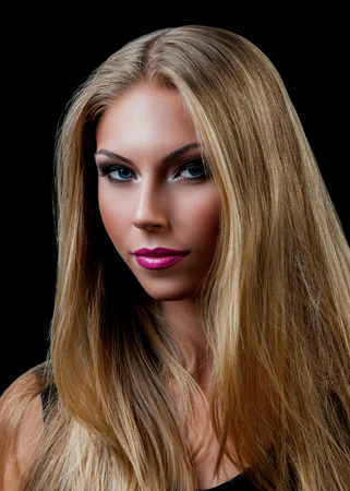 Professional Make up concept. Portrait of young beautiful woman with beauty makeup and perfect skin. Isolated on black backgroundの写真素材