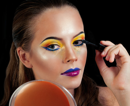 Professional Make up concept. Portrait of young beautiful woman with beauty makeup and perfect skin. Isolated on black backgroundの写真素材