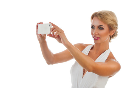 Portrait happy beautiful young woman taking selfie shot. Isolated on white backgroundの写真素材