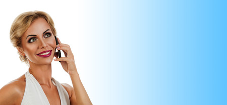 Portrait happy young woman talking on mobile phone on color backgroundの写真素材