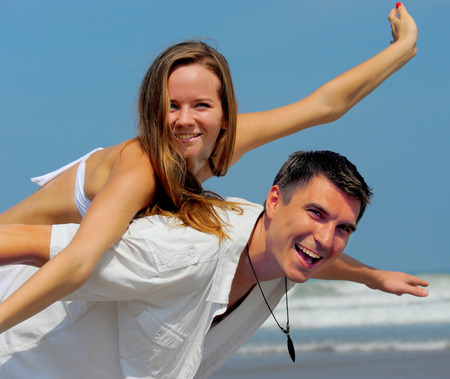 Young beautiful couple in love on a sunny beachの写真素材