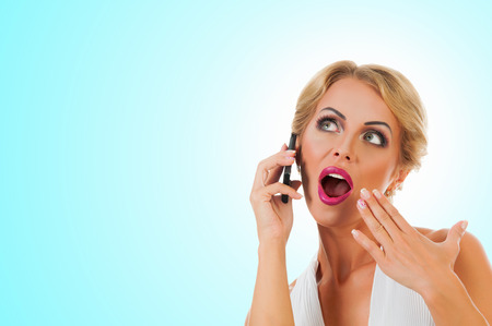 Portrait happy young woman talking on mobile phone on color backgroundの写真素材