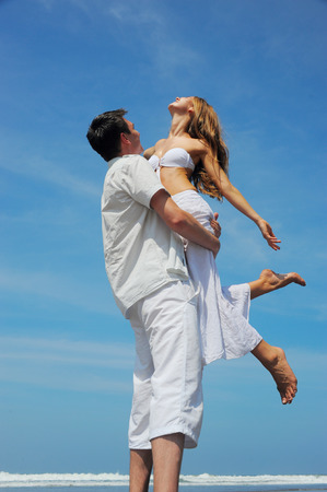 Young beautiful couple in love on a sunny beachの写真素材