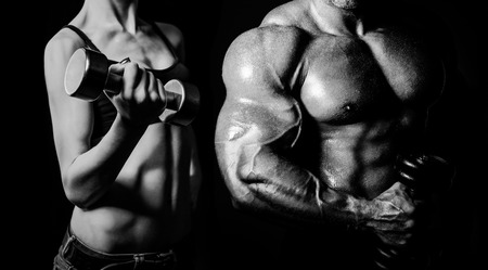 Bodybuilding. Strong man and a woman posing on a black backgroundの写真素材