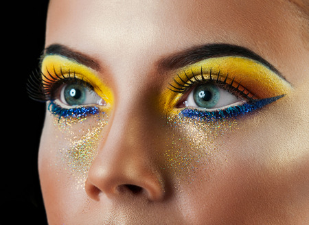 Professional Make up concept. Portrait of young beautiful woman with beauty makeup and perfect skin. Isolated on black backgroundの写真素材