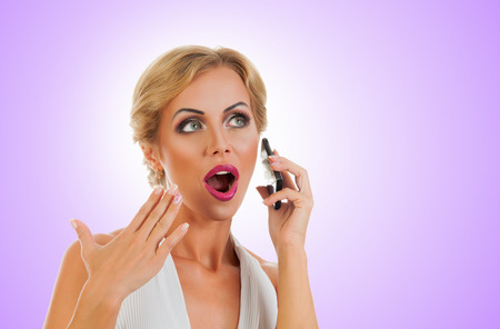 Portrait happy young woman talking on mobile phone on color backgroundの写真素材