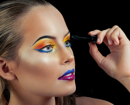 Professional Make up concept. Portrait of young beautiful woman with beauty makeup and perfect skin. Isolated on black backgroundの写真素材