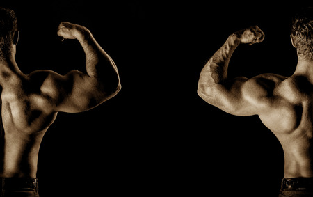 bodybuilder posing. Handsome power athletic guy male. Fitness muscular body on black background.の写真素材