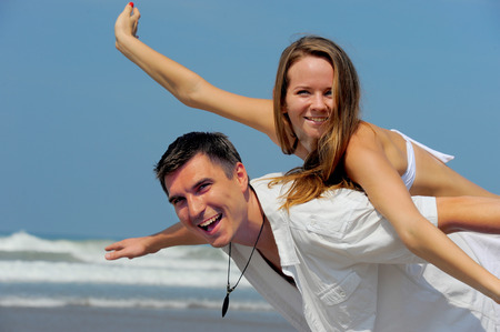 Young beautiful couple in love on a sunny beachの写真素材