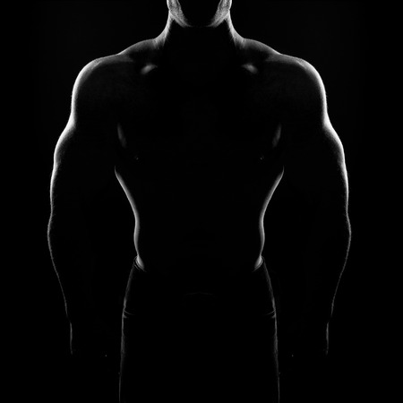 bodybuilder posing. Handsome power athletic guy male. Fitness muscular body on black background. Black and white photoの写真素材