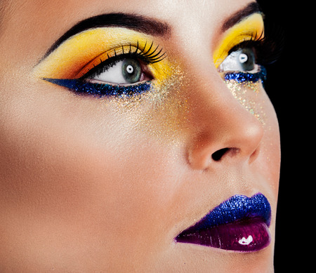 Professional Make up concept. Portrait of young beautiful woman with beauty makeup and perfect skin. Isolated on black backgroundの写真素材