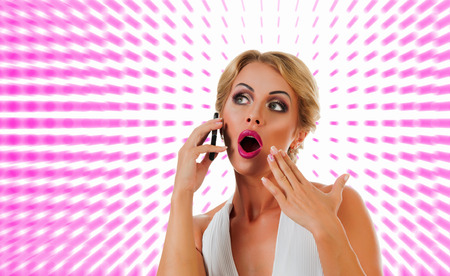 Portrait happy young woman talking on mobile phone on color backgroundの写真素材