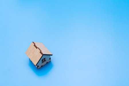 small toy wooden house on a blue background. High quality photoの写真素材