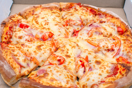 pizza with meat, cheese and vegetables in a cardboard box for delivery close up. High quality photoの写真素材