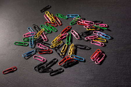 colored paper clips on a dark background. High quality photoの写真素材