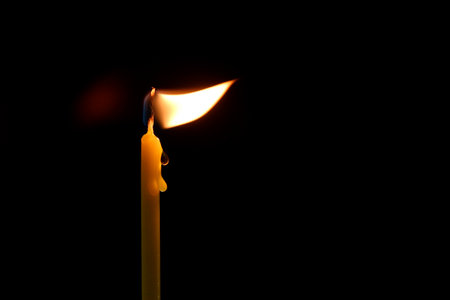 candle flame sways on a black background. High quality photoの写真素材