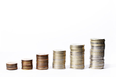 stacks of coins show the growth of income and the economy on a white background. High quality photoの写真素材