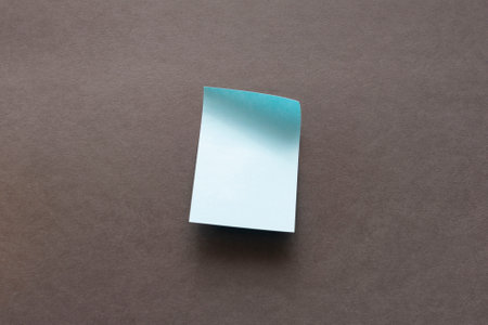 blank blue sticker for notes on a dark surface. High quality photo