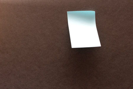blank blue sticker for notes on a dark surface. High quality photo