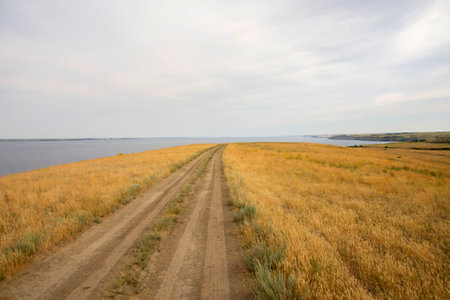 dirt road leading to the edge of a cliff above the water. High quality photoの写真素材