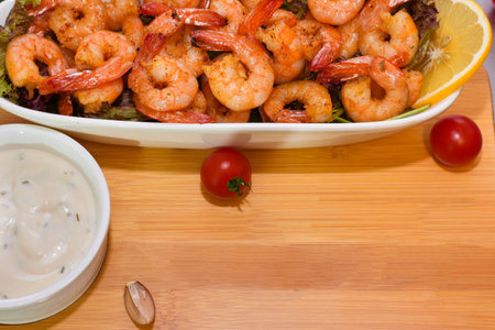 fried prawns on a plate with white sauce on a wooden background. High quality photoの写真素材