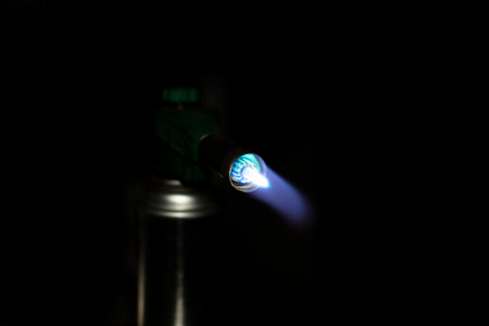 portable gas cylinder with a burning burner on a dark background. High quality photoの写真素材