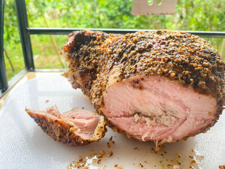 A large piece of pork smoked in a smoker against a background of nature. Smoke ring. High quality photoの写真素材