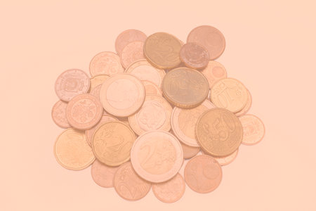 a handful of euro cent coins on a peach fuzz backgroundの写真素材