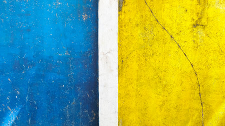 yellow-blue concrete wall with barbed wire on itの写真素材