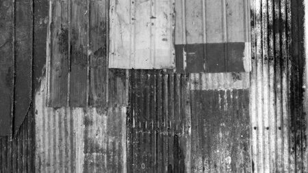 black and white roof covered with various old rusty materials of different colors.の写真素材