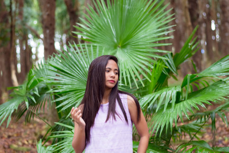 young Filipina woman against the background of the national Philippine palm leaf Livistona rotundifoliaの写真素材