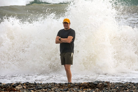 a man takes a selfie near the waves of the ocean.の写真素材