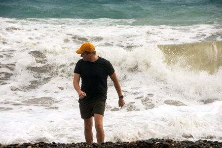 a man runs away from big waves on the sea coast.の写真素材
