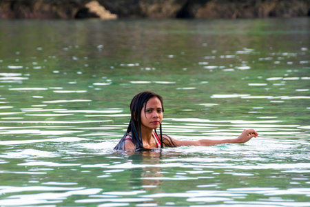 Young asian woman in swimsuit standing in tropical riverの写真素材