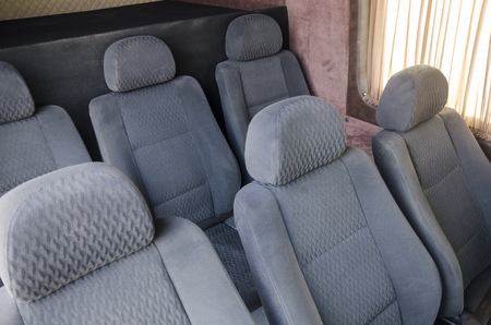 Wide view on interiors of the back of the car. Mild grey passenger seats of the bus. Transport saloon concept.の写真素材