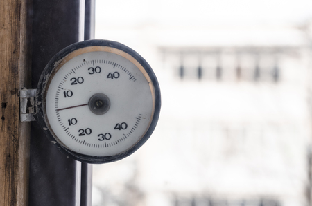 Window round thermometer close up view. Cold and snowy  weather is outside concept.の写真素材