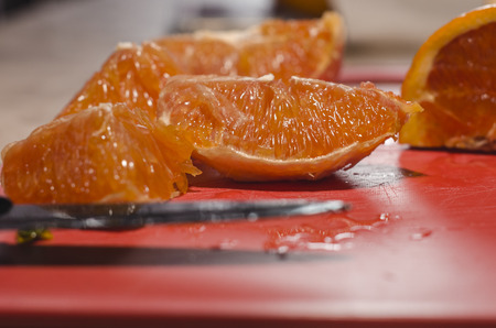 Juicy cutted slices of oranges on the red board. Organic natural fruits close up. Stay healthy concept.の写真素材