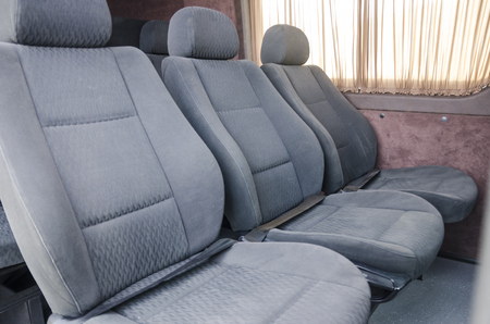 Wide view on interiors of the back of the car. Mild grey passenger seats of the bus. Transport saloon concept.の写真素材