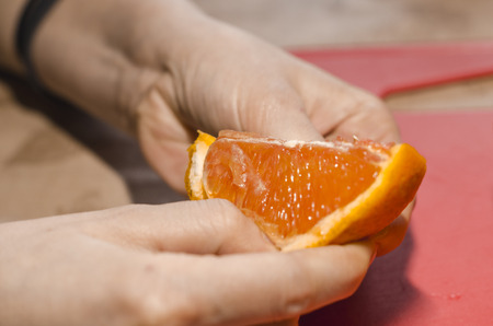 Slice of fresh juicy orange in the woman hand. Eating organic food concept. Stay on diet and be healthy.の写真素材