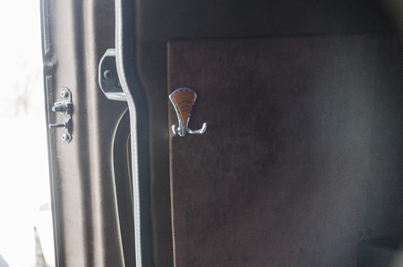 Wide view on interiors of the back of the car. Peg for hanging clothes on the mild side wall of the bus. Transport saloon concept.の写真素材