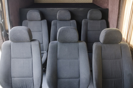 Wide view on interiors of the back of the car. Mild grey passenger seats of the bus. Transport saloon concept.の写真素材