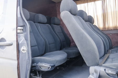 Wide view on interiors of the back of the car. Mild grey passenger seats of the bus. Transport saloon concept.の写真素材