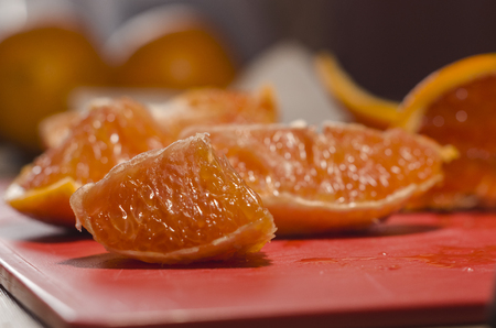 Juicy cutted slices of oranges on the red board. Organic natural fruits close up. Stay healthy concept.の写真素材