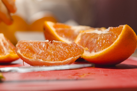 Juicy cutted slices of oranges on the red board. Organic natural fruits close up. Stay healthy concept.の写真素材
